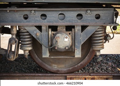 Dark railway carriage wheel with suspension details, closeup frontal photo