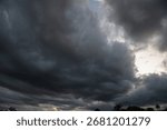 Dark rain cloud dramatic sky summer tropical thunder storm sky and fluffy black darkness cloud nearly raining cloudscape. Nimbus raincloud skyline climate background. Dark gray sky cloudy environment