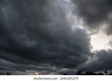 Dark rain cloud dramatic sky summer tropical thunder storm sky and fluffy black darkness cloud nearly raining cloudscape. Nimbus raincloud skyline climate background. Dark gray sky cloudy environment