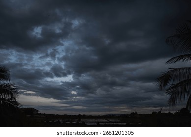 Dark rain cloud dramatic sky summer tropical thunder storm sky and fluffy black darkness cloud nearly raining cloudscape. Nimbus raincloud skyline climate background. Dark gray sky cloudy environment