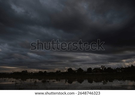 Dark rain cloud dramatic sky summer tropical thunder storm sky and fluffy black darkness cloud nearly raining cloudscape. Nimbus raincloud skyline climate background. Dark gray sky cloudy environment