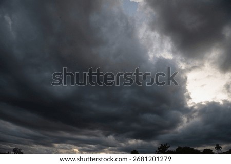 Dark rain cloud dramatic sky summer tropical thunder storm sky and fluffy black darkness cloud nearly raining cloudscape. Nimbus raincloud skyline climate background. Dark gray sky cloudy environment