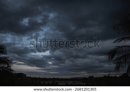 Dark rain cloud dramatic sky summer tropical thunder storm sky and fluffy black darkness cloud nearly raining cloudscape. Nimbus raincloud skyline climate background. Dark gray sky cloudy environment