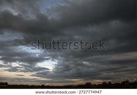 Dark rain cloud dramatic sky summer tropical thunder storm sky and fluffy black darkness cloud nearly raining cloudscape. Nimbus raincloud skyline climate background. Dark gray sky cloudy environment