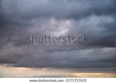 Dark rain clouds in the evening sky. Dramatic sky with an coming cloudy cyclone of bad weather