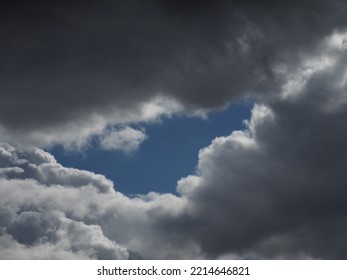 Dark Rain Clouds With A Streak Of Blue Sky