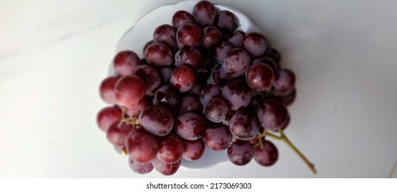 Dark Red Grapes On A White Plate