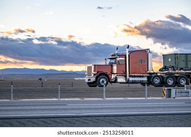 Dark red long haul industrial big rig semi truck tractor with extended cab for truck driver rest transporting fastened cargo on flat bed semi trailer running on the flan highway road at sunset time - Powered by Shutterstock