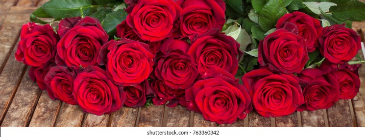 Dark Red Roses  Laying  On Wooden  Table