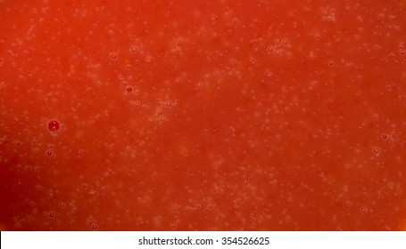 Dark red texture water with bubbles. Closeup. Tomato juice