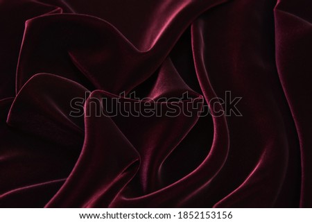 Dark red velvet fabric background texture.