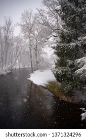 Dark River On Spring Day During Winter Snowstorm In Michigan 