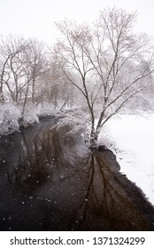 Dark River On Spring Day During Winter Snowstorm In Michigan 