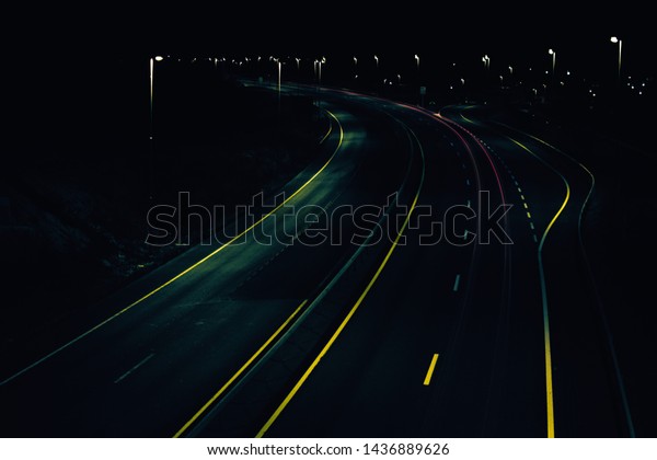 Dark road with glowing\
road markings