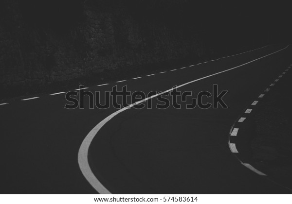 Dark road with white \
lines