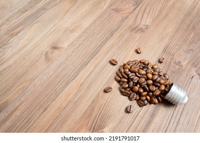 Dark Roasted Coffee Beans Arranged Into A Glowing Lightbulb Shape On A Wooden Table With Copy Space.