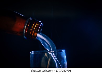 In the dark room of the bottle neck together with the liquor pours a trickle of smoke - it symbolizes the evil spirit of alcohol, copyspace