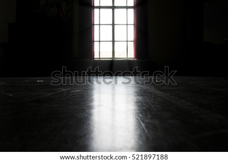 Dark room illuminated by bright light shining trough a window