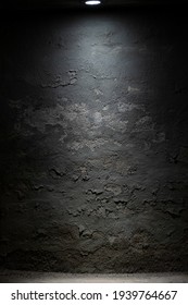 Dark Room Wall With Ceiling Light Background. Old, Weathered Cement And Stone Grey Wall With Peeled Paint And Stucco. Interrogation Room In The Basement. Low Key, Moody Space. Vertical, Copy Space