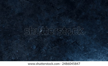 Dark rough cement wall background for graphic design or wallpaper. Grungy black and blue concrete texture in vintage style. The old plaster floor has a mysterious and terrifying age.
