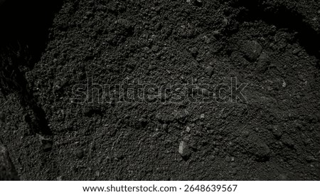 Dark, rough texture of fine coal under natural light, perfect for backgrounds
