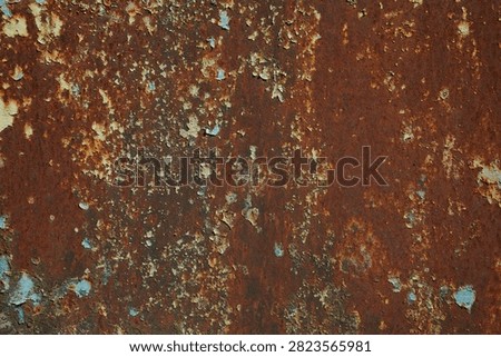 Dark rusty metal texture background closeup. Heavily corroded oxidized iron surface with deep reddish brown rust, flaking blue and yellow paint remnants, old industrial rustic wall material for grunge backdrop.