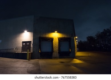 Dark And Scary City Warehouse Loading Dock And Entrance Door At Night.