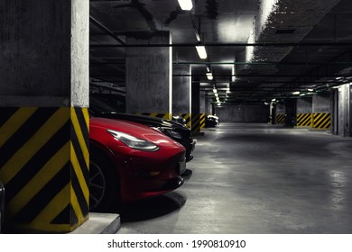 Dark scenic car park underground multilevel garage interior. Concrete cement column covered building basement floor electric vehicle parking lot zone. Modern urban city traffic infrastructure concept - Powered by Shutterstock