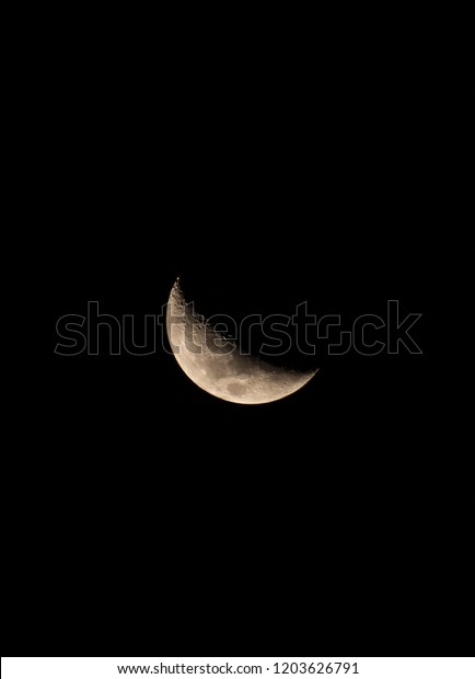 The dark side of the moon. A half moon shown\
in the city of Tandil, Argentina.\
