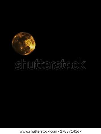 The dark side of the night warmed by the golden glow of the moon