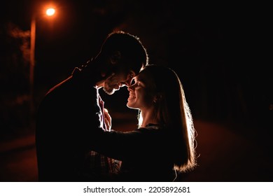 dark side view of attractive young couple flirting and looking each other. Romance couple. Love story. - Powered by Shutterstock