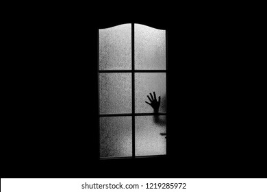 Dark Silhouette Of Hand Behind Glass In Supernatural Light. Locked Alone In Room Behind Door On Halloween. Nightmare Of Kid With Aliens, Monsters And Ghosts. Evil In Home. Сhild Inside Haunted House.