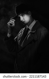 A Dark Silhouette Of A Man In A Raincoat And A Hat In The Style Of Crime Noir. A Dramatic Noir Portrait In The Style Of Detectives Of The 1950s.