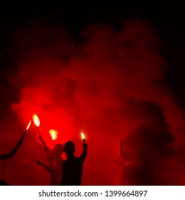 dark silhouette people holding bengal lights and dancing like hooligans - Shutterstock ID 1399664897