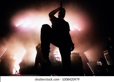 Una silueta oscura de un cantante en el escenario. Fondo de buen aspecto, luces de emergencia brillantes. Un concierto de una famosa banda musical