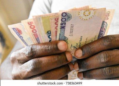 Dark Skin Man's Hand Counting Five Hundred Naira Note Savings Jar Notes 