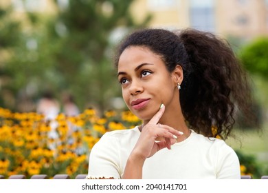 Dark Skinned Brunette Female With Loose Wavy Curls African American Hair. Outdoor Lifestyle Portrait Of African American Young Woman. Hipster Mixed Race Black Girl. Soft Focus.