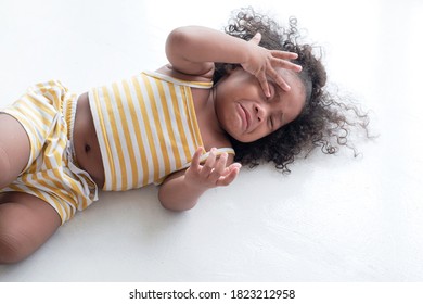 Dark Skinned Child Crying And Shouting With Tantrum Laying On The Floor At Home