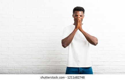 Dark skinned man smiling a lot while covering mouth