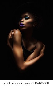 Dark Skinned Woman On A Black Background With A Fashionable Hat On His Head