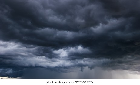 The dark sky with heavy clouds converging and a violent storm before the rain.Bad or moody weather sky and environment. carbon dioxide emissions, greenhouse effect, global warming, climate change - Shutterstock ID 2220607227