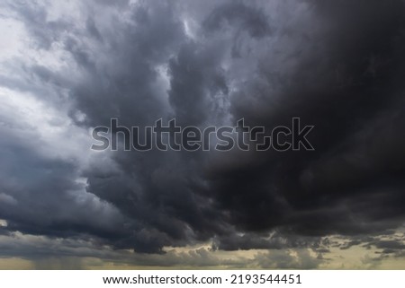 The dark sky with heavy clouds converging and a violent storm before the rain.Bad weather sky.