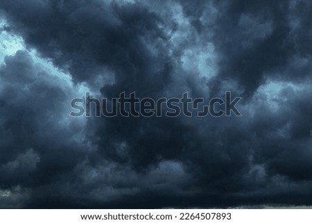 The dark sky with heavy clouds converging and a violent storm before the rain.Bad or moody weather sky and environment. carbon dioxide emissions, greenhouse effect, global warming, climate change