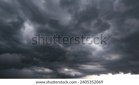 The dark sky with heavy clouds converging and a violent storm before the rain.Bad or night weather sky and environment. carbon dioxide emissions, greenhouse effect, global warming, climate change