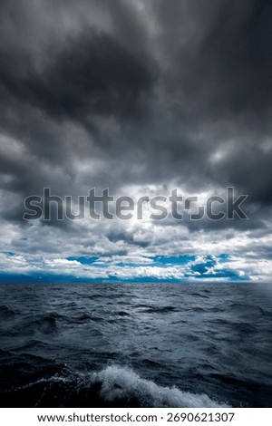 The dark sky with heavy clouds converging and a violent storm before the rain.Bad or moody weather sky and environment. carbon dioxide emissions, greenhouse effect, global warming, climate change.
