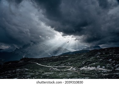 Dark Sky In The Mountains Before Sunset. Sun Rays, Dark Clouds On The Sky, Dark Green Grass And Many Stones On The Hills.