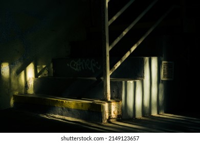 Dark and spooky urban staircase lit by evening sun