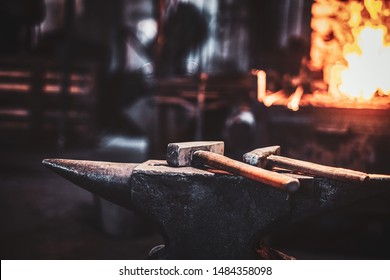 Dark stithy workshop with hammer on anvil at firs plan and fire in stove at background. - Powered by Shutterstock