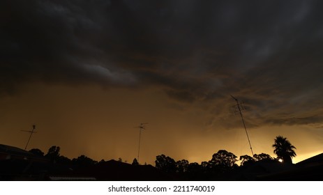 Dark Storm Cell Approaching Suburban Town At Sunset During Australian Spring.