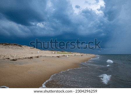 Dark storm clouds above the empty sandy beach.